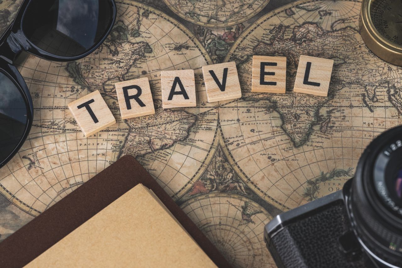 creative-02 Vintage map with travel essentials like camera and sunglasses arranged in a flat lay, perfect for adventure themes.