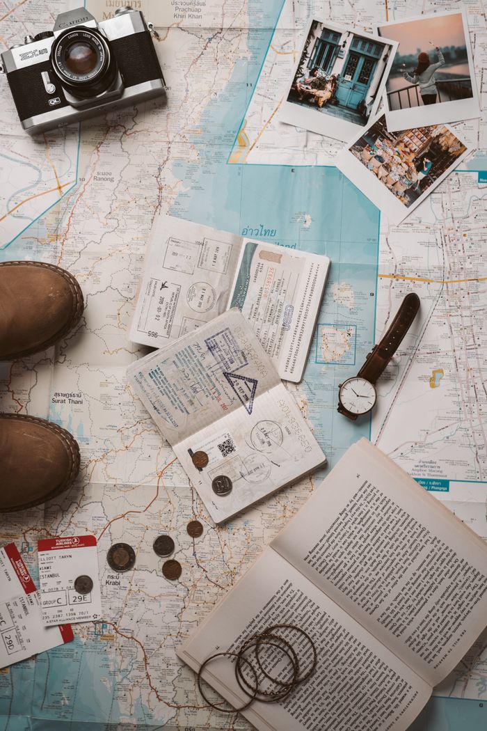 creative-01 Flat lay of travel essentials featuring a map, camera, and passport stamps, perfect for wanderlust inspiration.